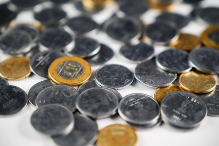 Various golden and silver coins grouped together, showcasing shiny metallic texture and value. A...