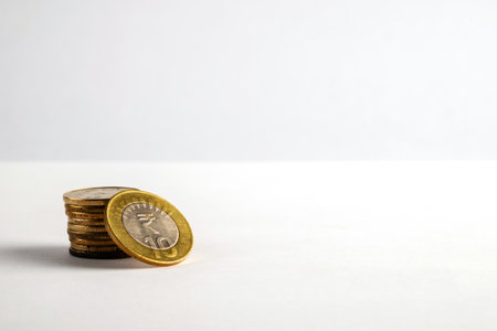 A neat stack of gold coins displayed on a plain white surface, symbolizing financial concepts like savings, investments, and currency. This minimalist composition portrays simplicity and monetary values.の写真素材