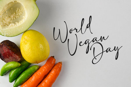 A vibrant arrangement of fresh vegetables and fruits accompanied by stylized text celebrating World Vegan Day, highlighting healthy and plant-based dietary choices.の写真素材