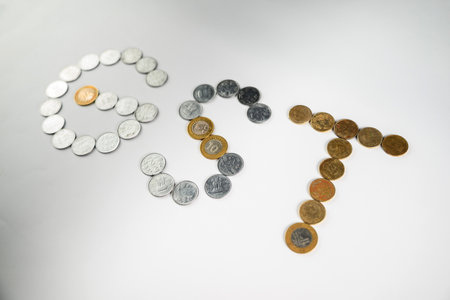 Depiction of monetary coins arranged to form the acronym 'GST,' symbolizing the financial and taxation concept related to the Goods and Services Tax policy.の写真素材
