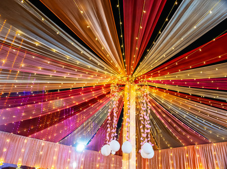 Festive draped ceiling adorned with colorful lights and ornamental decorations, creating a vibrant ambiance suitable for celebrations. The interplay of light and fabric sets a joyous and inviting mood.の写真素材