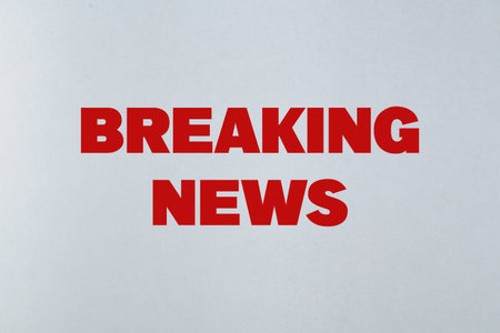 Bold red text reading 'Breaking News' displayed prominently on a light neutral background, conveying...