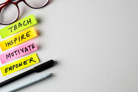 Colorful sticky notes with motivational words next to writing tools and glasses on a white surface, symbolizing creativity, purpose, and personal development.の写真素材