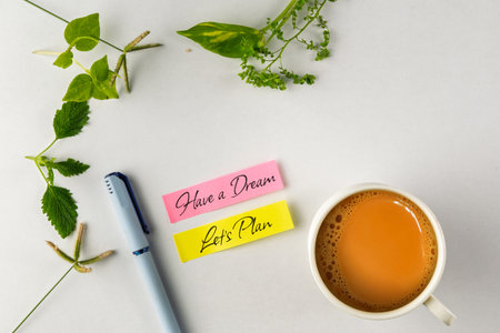 Colorful handwritten notes alongside a coffee cup, a pen, and green leaves, representing productivity and planning. An inspiring composition instilling motivation and creative work energy.の写真素材