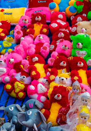 A vibrant arrangement of plush toys featuring colorful teddy bears and dolls, creating a cheerful and playful setting. Perfect for themes involving gifts, celebrations, and childhood memories.の写真素材