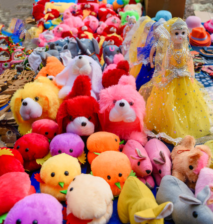 A vibrant arrangement of plush toys featuring colorful teddy bears and dolls, creating a cheerful and playful setting. Perfect for themes involving gifts, celebrations, and childhood memories.の写真素材