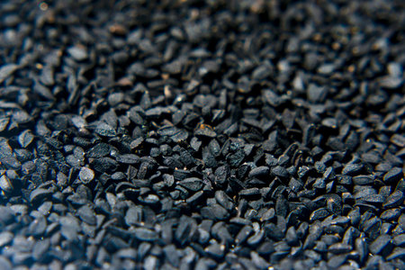Highly detailed macro photograph showcasing small black cumin forming an intricate textured surface, emphasizing industrial and natural themes with unique visual appeal in detail and composition.の写真素材