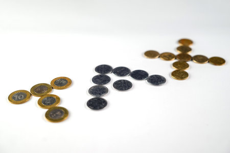 Close-up of coins creatively arranged to form the word 'tax' on a simple white surface. A concept for finance, taxes, and monetary discussions, represented through currency illustrations.の写真素材