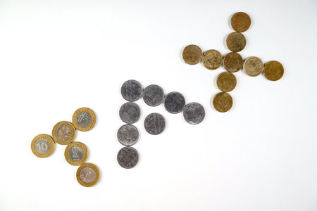 Close-up of coins creatively arranged to form the word 'tax' on a simple white surface. A concept for finance, taxes, and monetary discussions, represented through currency illustrations.の写真素材