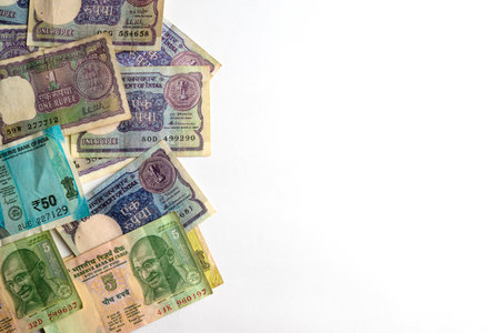 A mix of vintage and modern Indian banknotes in various denominations, spread over a white surface, showing their unique designs and historical significance in currency evolution.の写真素材