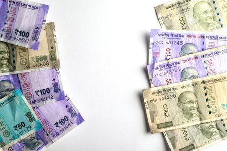 Indian paper currency denominations of 50, 100, and 500 rupees featured neatly on a blank white...