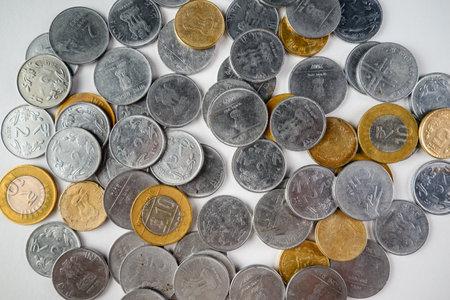 An array of Indian coins in mixed denominations, showcasing metallic textures and designs, representing currency and finance.の写真素材