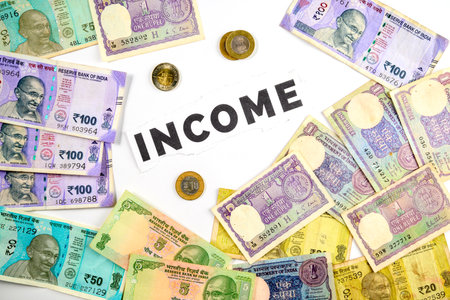 Various Indian rupee notes and coins are arranged around the central concept of 'income',...