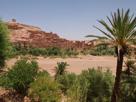 Kasbah Ait Benhaddou (Ksar of Ait-Ben-Haddou) door to the Sahara Desert in Morocco behind palm trees, UNESCO World Heritageの写真素材