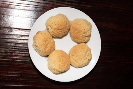 Fives pieces of homemade bread on a white plate, on a wooden table