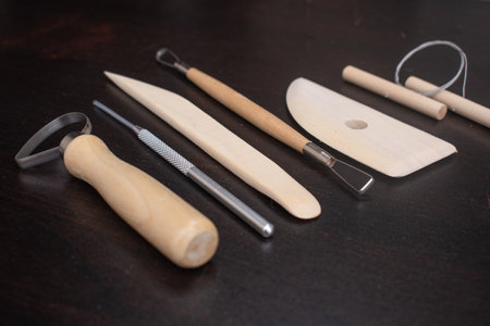 tools for sculpting clay, on a wooden tableの写真素材