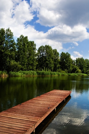 A wooden dock / pier on a lake in summer sunny dayの写真素材