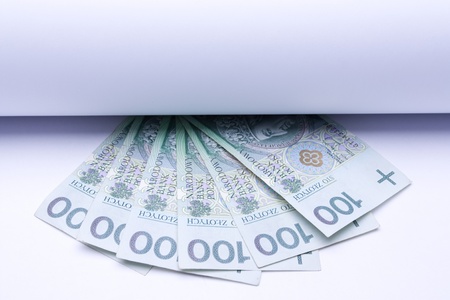 polish money: zloty, banknotes under roll of paper for text or designの写真素材