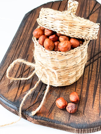 hazelnuts in a basket on a white tableの写真素材