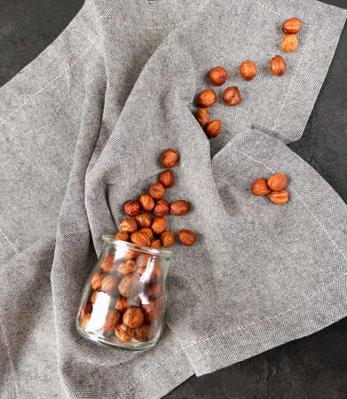 sprinkled hazelnuts on black concreteの写真素材