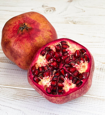 two ripe pomegranates on a wooden tableの写真素材