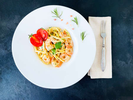 pasta with shrimps and tomatoes on the table
