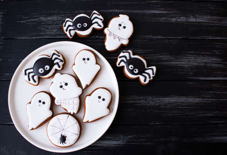gingerbread cookie for halloween treat for kids on black wooden backgroundの写真素材