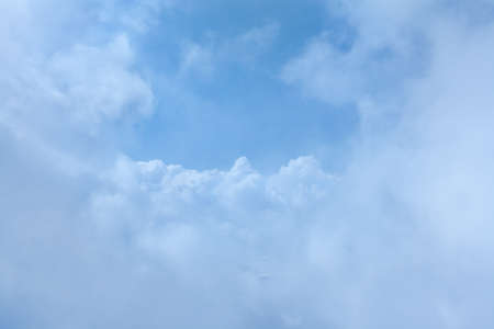 Deep blue sky and clouds in the form of the mountains in the center of the frame