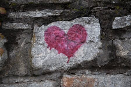 red heart - love symbol on old stone wallの写真素材