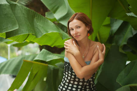 Beautiful woman on leaves of palm backgroundの写真素材