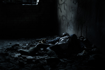Dead woman lying on the dirty floor in a heap of rubbish in the basementの写真素材