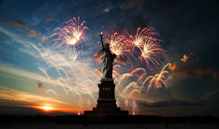 Statue of Liberty on the background of sunrise and fireworks