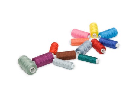 Different colored spools of thread forming a flower isolated on the white background