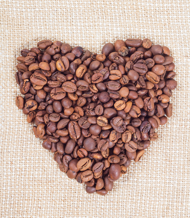 Coffee beans in the form of heart on background of burlapの写真素材