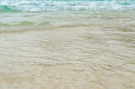 Close up Wave of The Ocean, White Sand on Summer Beach and Surface Water Foam.の写真素材