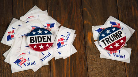 Washington DC--July 5, 2020; Joe Biden and Donald Trump campaign buttons sitting on piles of I Voted...