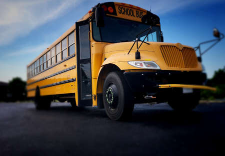Low angle view of the front door side entrance of a yellow American public school bus used to...
