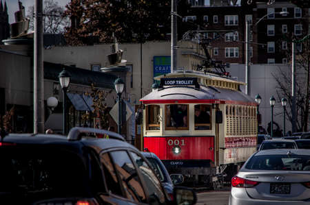 Saint Louis, MO--Nov 23, 2018; red and yellow antique street car trolley moves through university...