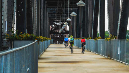 Little Rock, AR--May 22, 2018; bicyclists ride in a line across the William Jefferson Clinton pedestrian bridge in downtown across to North Little Rock.のeditorial素材