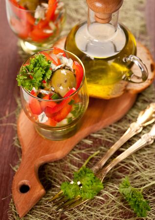 Salad of tomatoes, cucumbers and sweet peppers and a bottle of olive oilの写真素材