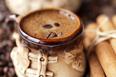 cup of delicious coffee with cinnamon sticks and coffee beansの写真素材