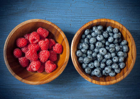 Raspberries and blueberries in a wooden bowlの写真素材