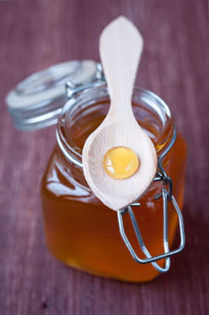 Honey in jar with wooden spoonの写真素材