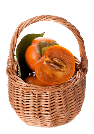 persimmons in a basket on a white backgroundの写真素材
