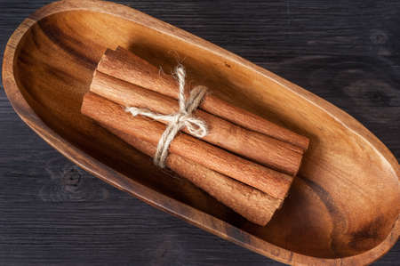 Cinnamon sticks in a wooden bowl