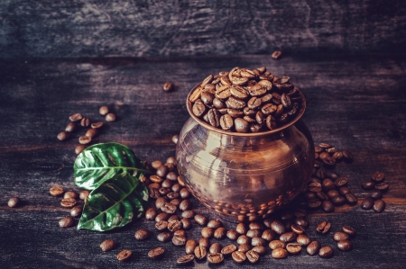 Coffee grains with green leaves in a copper potの写真素材