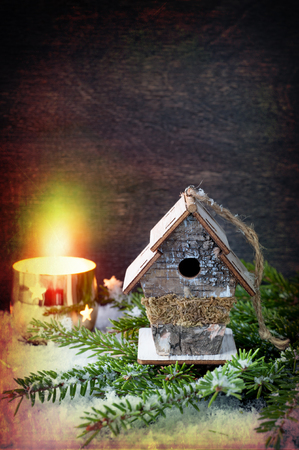 Christmas Decorations: birdhouse and a burning candle. Retro Style.
の写真素材