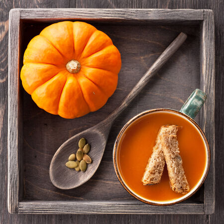 Cup of pumpkin soup with croutons in a vintage trayの写真素材