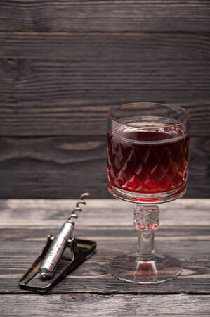 Red wine and vintage corkscrew on wooden backgroundの写真素材