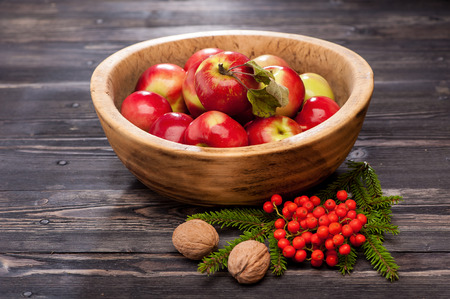 Red apples in a wooden bowl. Autumn composition.の写真素材